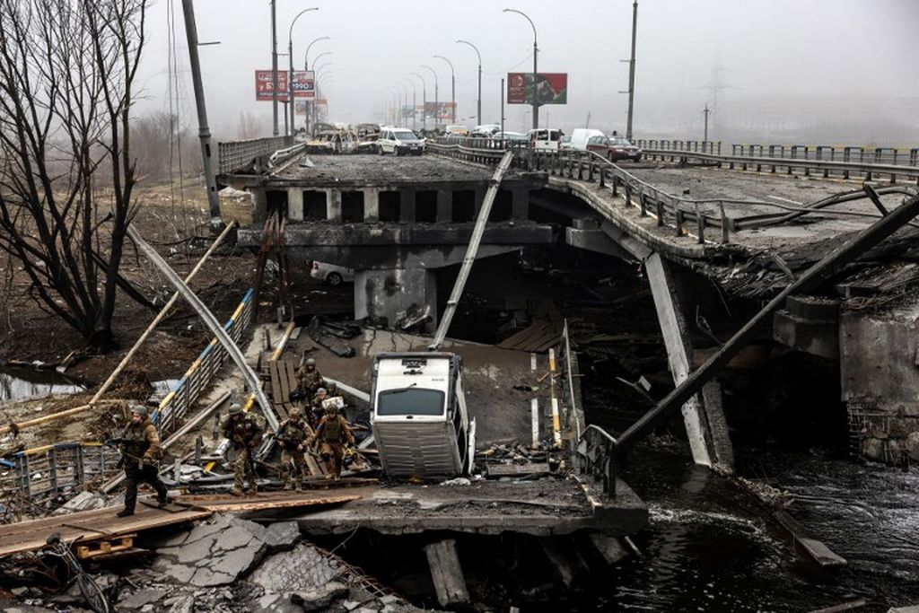 Tentara Ukraina melewati jembatan yang hancur  akibat invasi Rusia ke Ukraina di pintu masuk Irpin, dekat ibu kota Kiev, Jumat, 1 April 2022. 