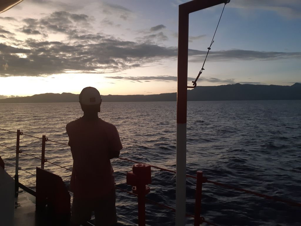 Penumpang melihat ke arah Pulau Atauro, negara Timor Leste, dari atas kapal perintis Sabuk Nusantara 67 Matahari, Minggu (7/8/2022). Pulau Atauro masih sering didatangi warga Indonesia yang memiliki hubungan keluarga dengan warga di pulau itu.