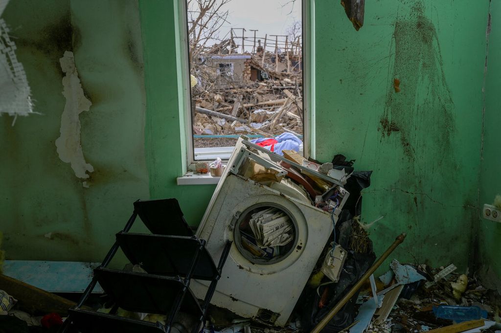 Sebuah rumah dengan kondisi area permukiman warga yang hancur setelah militer Rusia menyerang sebuah desa di dekat Mykolaiv, Ukraina, Minggu (27/3/2022). Serangan yang berlangsung selama beberapa minggu itu menyebabkan kehancuran serta menghentikan aktivitas area pelabuhan terbesar di Ukraina. (BULENT KILIC / AFP)