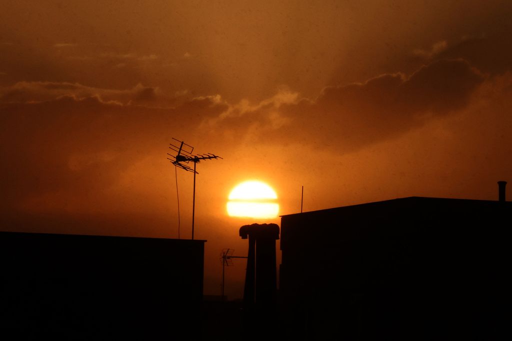 Matahari terbenam dengan latar depan bangunan gedung, di Teheran, Iran, 7 Agustus 2023. 