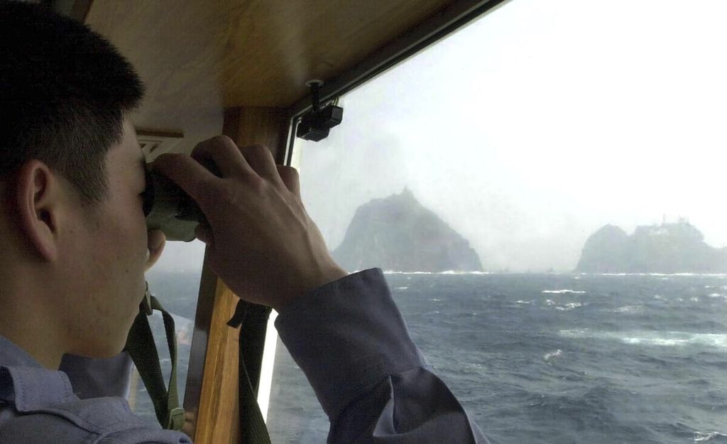 In a photo taken on April 28, 2005, a member of the South Korean Coast Guard is seen monitoring the waters around Dokdo Island, or according to the Japanese, known as Takeshima Island.
