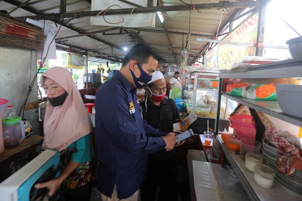 Pedagang kuliner di Pasar Mayestik, Jakarta Selatan, mendengarkan penjelasan tenaga pemasar mikro Bank Mandiri tentang aplikasi kredit mikro daring milik Bank Mandiri, Senin (29/6/2020). 