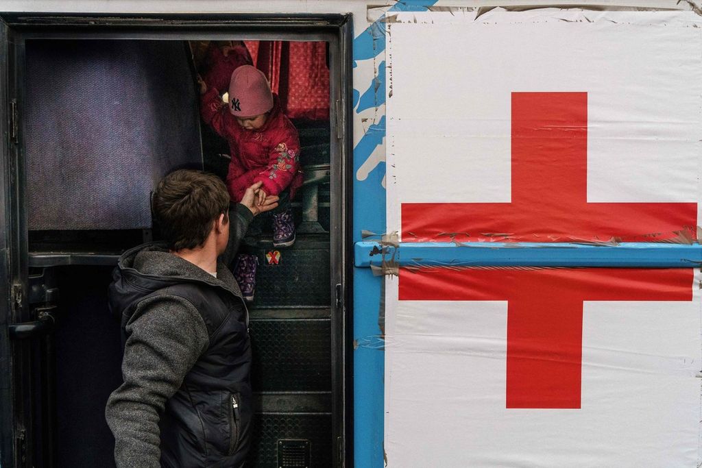 Seorang anak tengah dibantu turun dari bus di pusat registrasi di Zaporizhzhia, dimana Komite Palang Merah Internasional menempatkan tim. Foto diambil pada Jumat (1/4/2022).