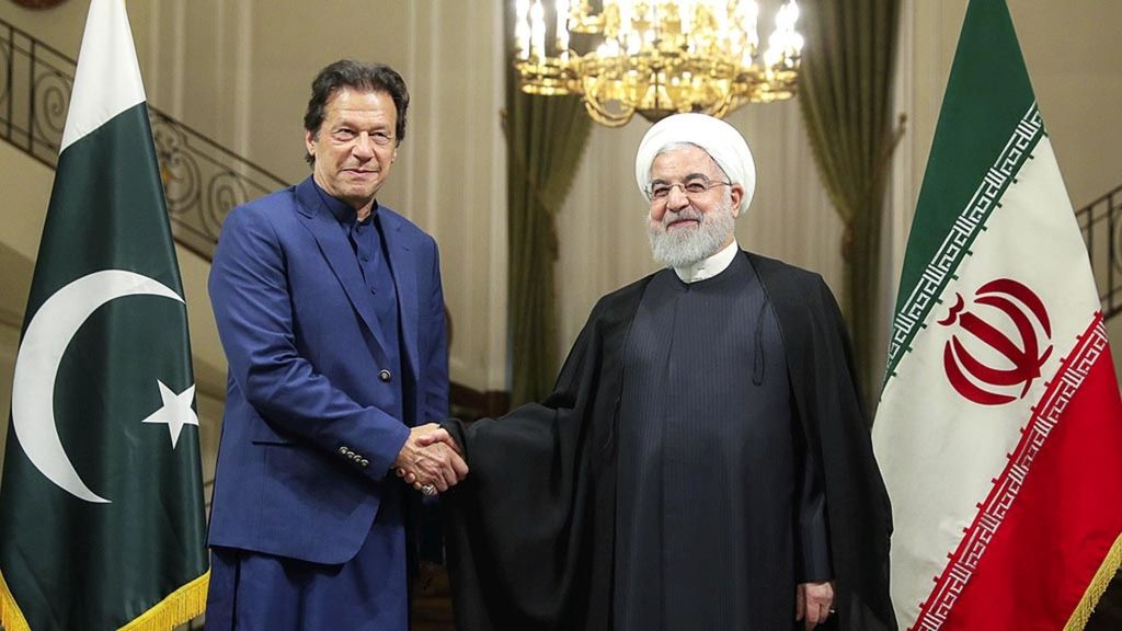 Foto yang dirilis Kantor Kepresidenan Iran, Minggu (13/10/2019), memperlihatkan Presiden Hassan Rouhani (kanan) berjabat tangan dengan Perdana Menteri Pakistan Imran Khan di ibu kota Iran, Teheran.