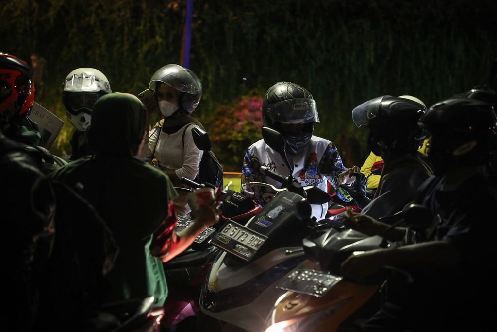 Homecoming travelers on motorbikes talk while queuing to enter the ferry at Bakauheni Harbor, Lampung, Tuesday (25/4/2023).