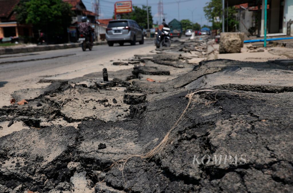 Lapisan aspal yang mengelupas setelah terendam dan terkena arus banjir yang merendam jalur pantura Demak-Kudus di Kecamatan Karanganyar, Kabupaten Demak, Jawa Tengah, Minggu (24/3/2024). 