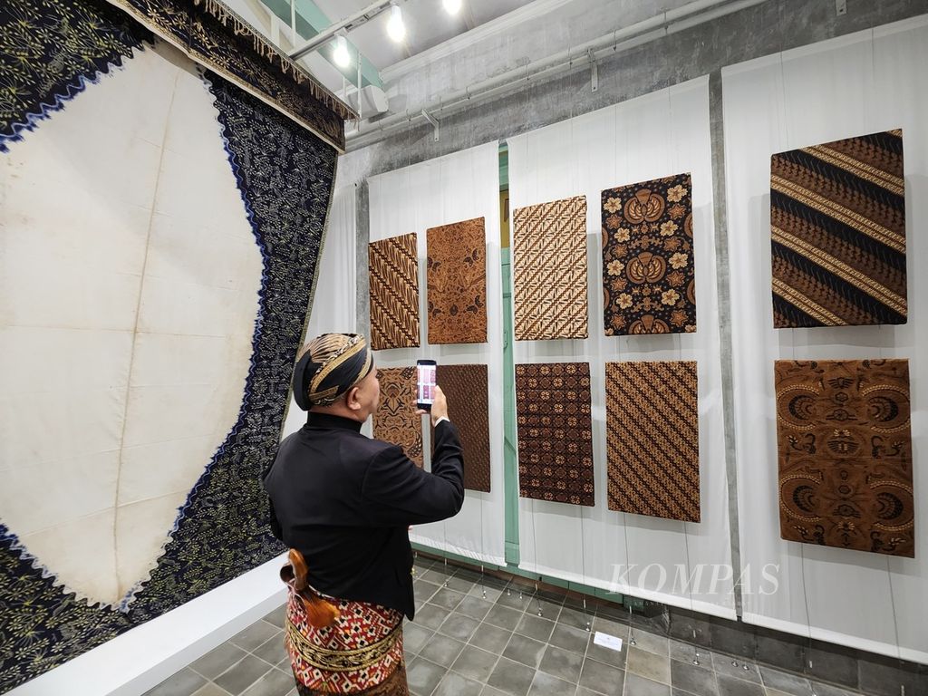 Pengunjung menyaksikan koleksi batik milik Pura Mangkunegaran dalam pergelaran "Angsukayana" di Pura Mangkunegaran, Kota Surakarta, Jawa Tengah, Minggu (29/10/2023)