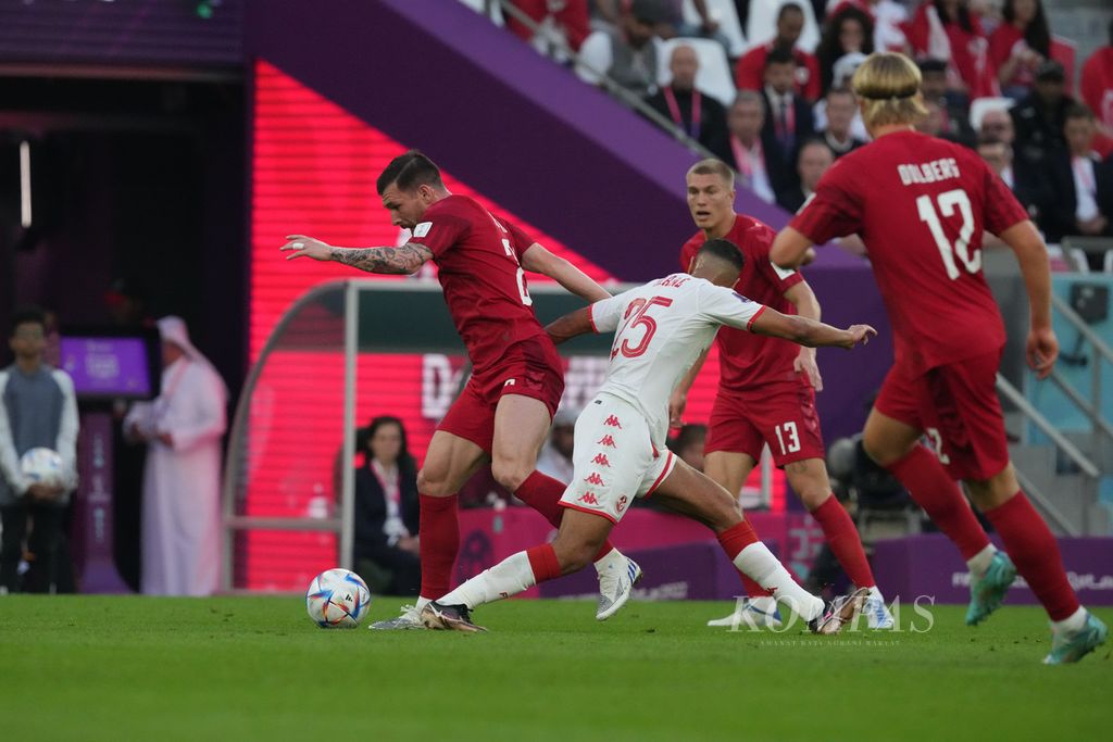 Pemain Denmark Pierre-Emile Hojbjerg berebut bola dengan pemain Tunisia di babak fase grup C Piala Dunia 2022 di Stadion Education City, Qatar, Selasa (22/11/2022). Pertandingan berakhir imbang 0-0. 