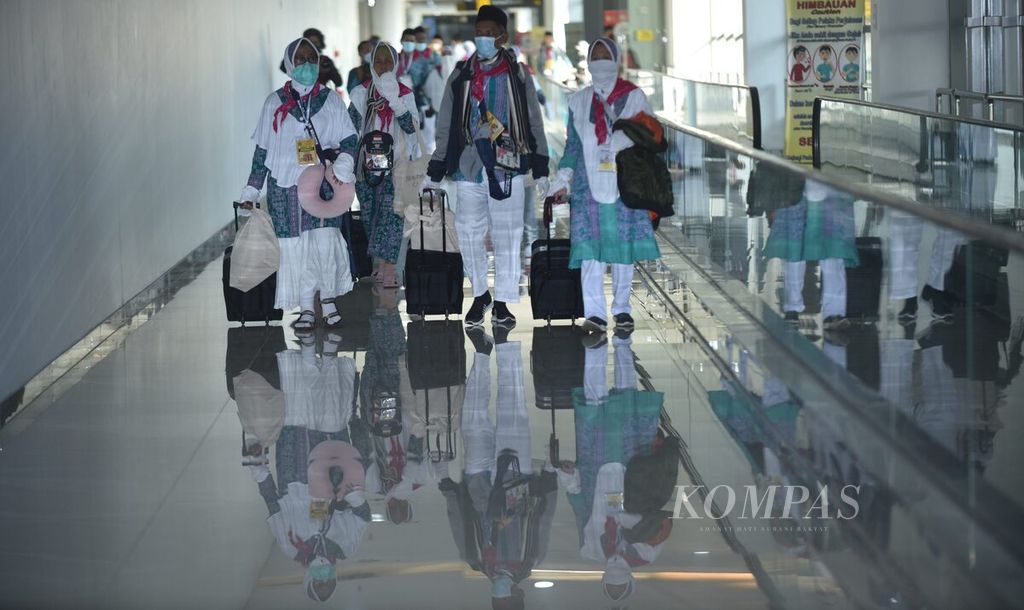 Para calon jemaah haji Kloter 1 Embarkasi Surabaya berjalan menuju pesawat terbang yang akan membawa mereka ke Tanah Suci di Terminal 2 Bandara Juanda Surabaya di Sidoarjo, Jawa Timur, Sabtu (4/6/2022). Pemberangkatan Kloter 1 ini menjadi yang pertama dilakukan setelah dua tahun ditiadakan akibat pandemi Covid-19. 