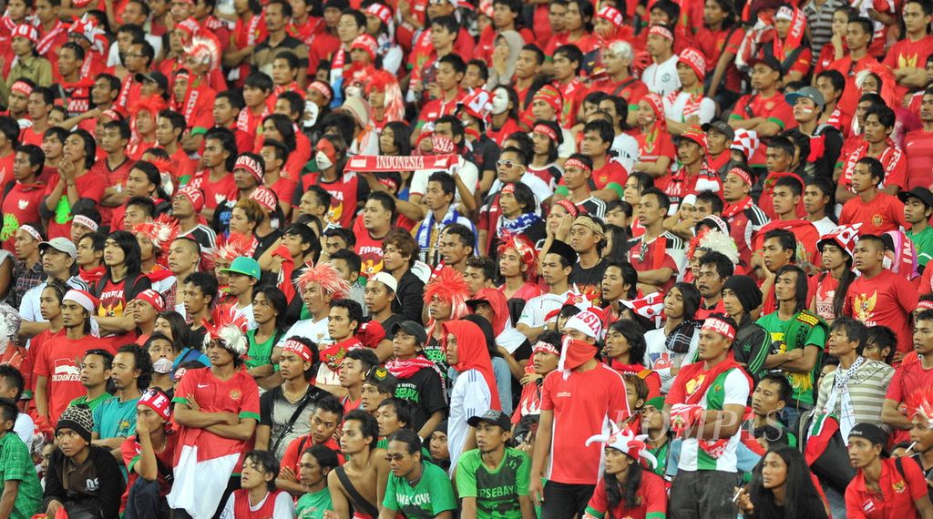 Suporter timnas Indonesia termangu dalam ketegangan saat menyaksikan tim kebanggaan mereka dikalahkan timnas Malaysia dalam laga penyisihan Piala AFF 2012 di Stadion Nasional Bukit Jalil, Malaysia, 1 Desember 2012. 