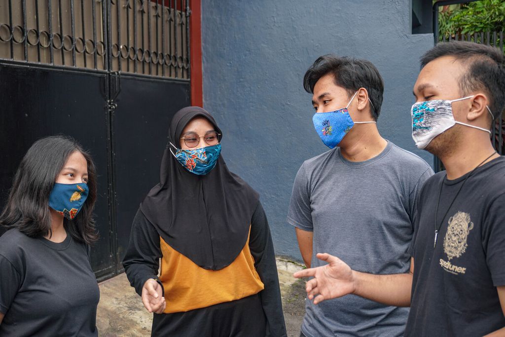 Para anak muda sedang bercengkerama memakai masker kain bermotif, Kamis (25/11/2021).