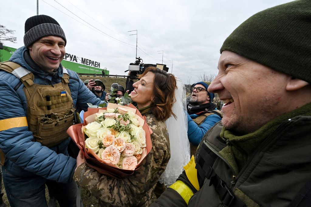 Kyiv mayor Vitali Klitschko congratulates the servicemen of Ukrainian territorial defence, Valery (R) and Lesya (C), with their wedding not far from check-point on Kyiv outskirts on March 6, 2022. 