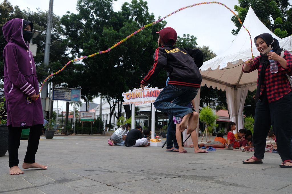 Warga bermain lompat tali di kawasan Kota Tua, Jakarta, Sabtu (12/11/2022). Acara yang berlangsung dari tanggal 12 sampai 13 November tersebut bertujuan untuk mengenalkan permainan tradisional kepada generasi muda. Sebanyak sembilan permainan tradisional dihadirkan dalam acara tersebut, di antaranya engklek, lompat tali, dan rangku alu. 