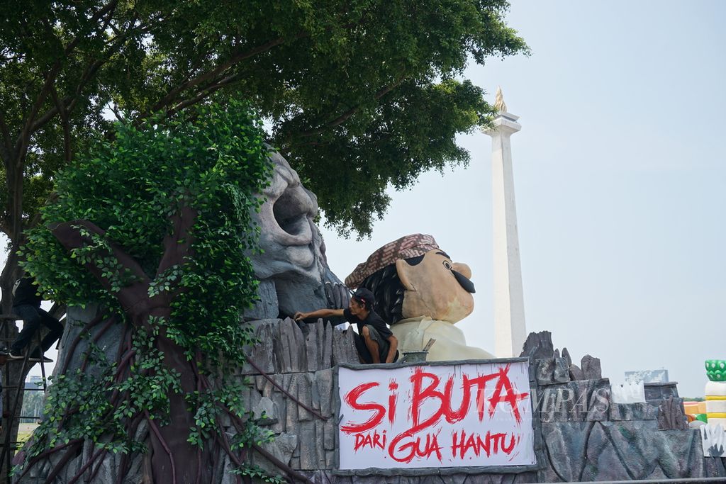 Pekerja mengecat dekorasi mobil hias untuk parade dalam malam perayaan Tahun Baru 2024 bertajuk ”Malam Muda Mudi, Jakarta Kota Global”, di kawasan Monas, Jakarta Pusat, Kamis (28/12/2023).