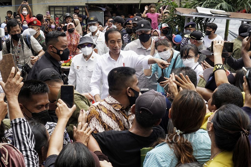 Presiden Joko Widodo menyapa warga saat berkunjung ke Pasar Klandasan, Kota Balikpapan, Kalimantan Timur, Selasa (25/10/2022). Dalam kunjungan ini, Presiden membagikan bantuan langsung tunai dan sembako kepada warga.