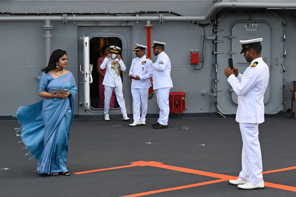 Seorang perwira Angkatan Laut mengambil gambar seorang perempuan di dek kapal induk buatan India INS Vikrant saat penugasannya di Galangan Kapal Cochin di Kochi, India, Jumat (2/9/2022). India memulai debut kapal induk buatan lokalnya pada 2 September 2022. 