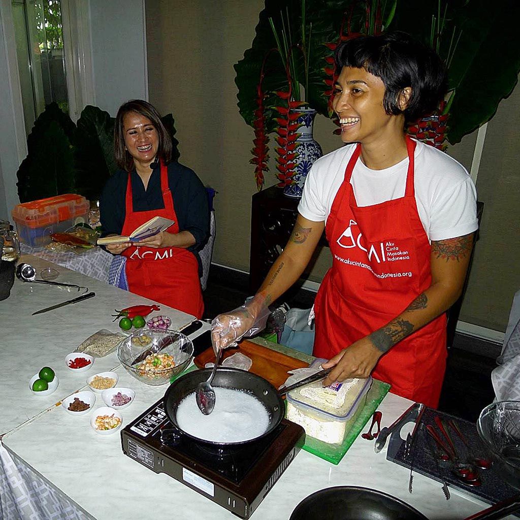 Pendiri Aku Cinta Makanan Indonesia (ACMI) Santhi Serad (kiri) dan Humas ACMI Ade Putri Paramadita memasak sambel majoor.