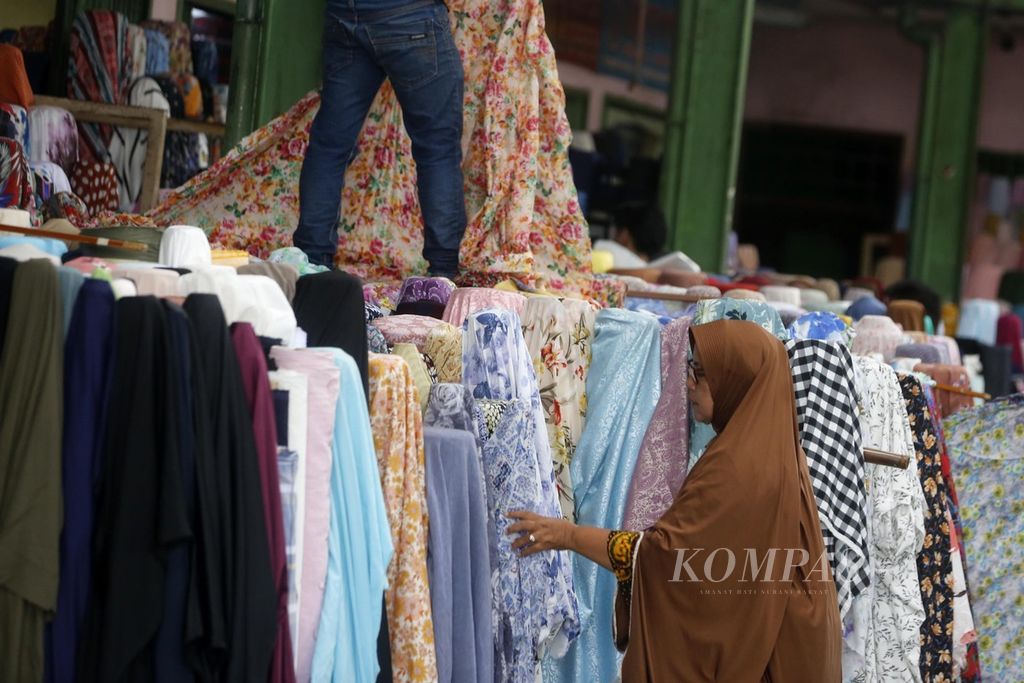 Pengunjung memilih kain yang ditawarkan pedagang di Pasar Tekstil Cipadu, Kota Tangerang, Banten, Jumat (27/1/2023). 
