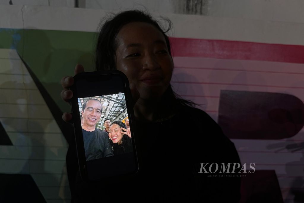 Seorang pengunjung menunjukkan swafotonya bersama Presiden Joko Widodo di kedai Mie Gacoan di Kota Mataram, Nusa Tenggara Barat, Selasa (30/4/2024) malam. Presiden berada di Lombok dalam rangka kunjungan kerja di Nusa Tenggara Barat yang berlangsung pada 30 April-2 Mei 2024.