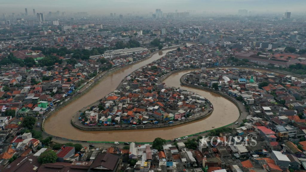 Foto udara kenaikan tinggi muka air Sungai Ciliwung di kawasan Kampung Melayu, Jakarta Timur dan Bukit Duri, Jakarta Selatan, Selasa (22/9/2020). Tinggi muka air di Bendung Katulampa pada hari Senin 21/9/2020) pukul 18.00 WIB menyentuh angka 240 cm dan memberikan peringatan awas/siaga 1, namun lambat laun surut dan kembali normal. Ibu Kota berupaya agar siap menghadapi musim hujan pada paruh kedua tahun ini dengan mengeruk sedimentasi di badan air atau waduk-waduk, serta membersihkan saluran-saluran air. Langkah itu baik, tetapi kurang berjangka panjang. Pemeliharaan saluran air dan tempat penampungan air yang terkoneksi dengan peta pembuangan air Ibu Kota lebih penting daripada sekadar membangun mekanisme resapan. Kian berkurangnya lahan resapan akibat alih fungsi untuk pembangunan gedung dan infrastruktur lainnya mendesak untuk dibuatkan tali-tali air yang berhubungan.