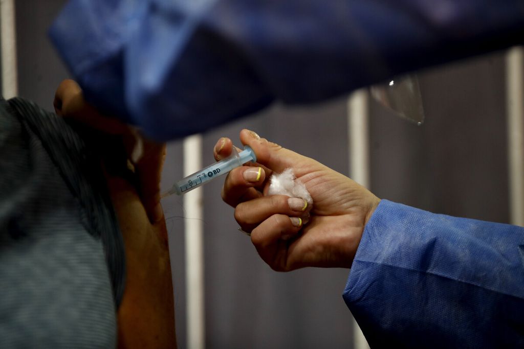 Petugas kesehatan menerima vaksin Sputnik V COVID-19 produksi Rusia saat berlangsung vaksinasi massal di stadion River Plate di Buenos Aires, Argentina, Selasa (2/2/2021). 