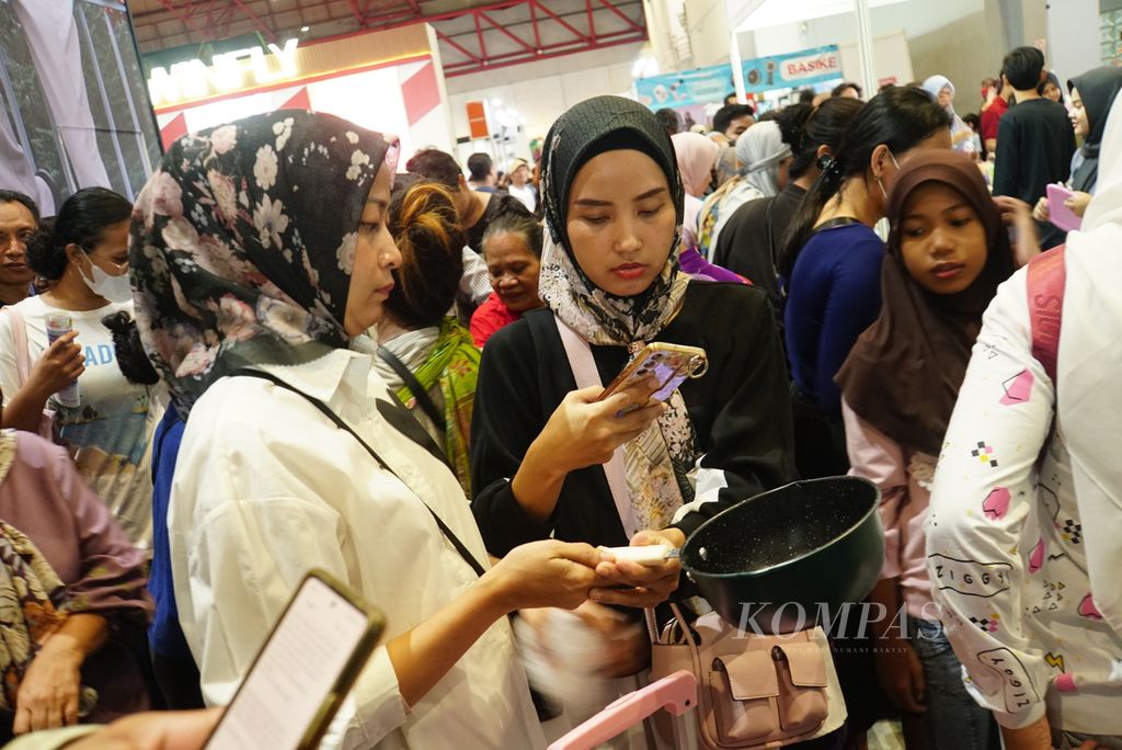 Pengunjung memotret perabotan dapur yang hendak dibeli dalam gelaran cuci gudang Big Bang Festival 2023 di JIExpo Kemayoran, Jakarta, Kamis (28/12/2023). 