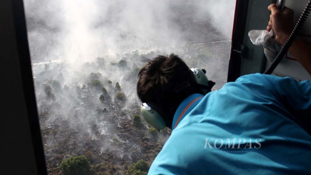 Pemantauan titik api di Desa Cinta Jaya, Kecamatan Pedamaran, Kabupaten Ogan Komering Ilir, Sumatera Selatan, menggunakan helikoper MI 172-VN 8427, Kamis (19/7/2018). 