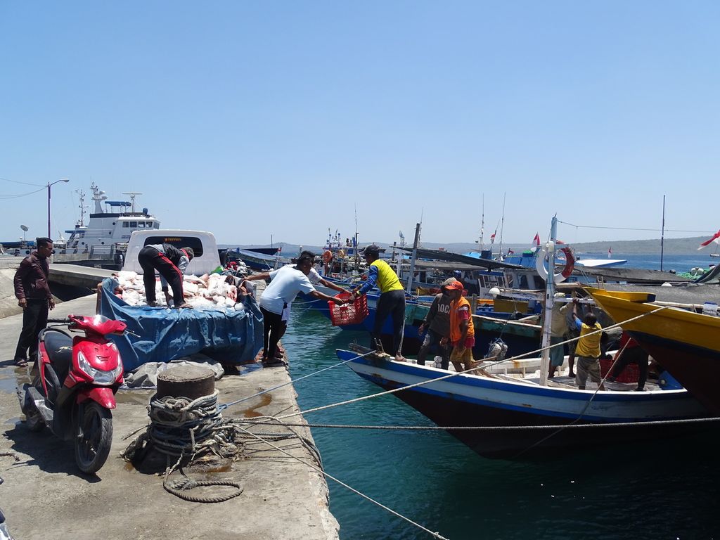 Nelayan membongkar ikan dari dalam kapal ke dalam mobil pikap milik pengusaha ikan di Kupang, Senin (24/6/2019).