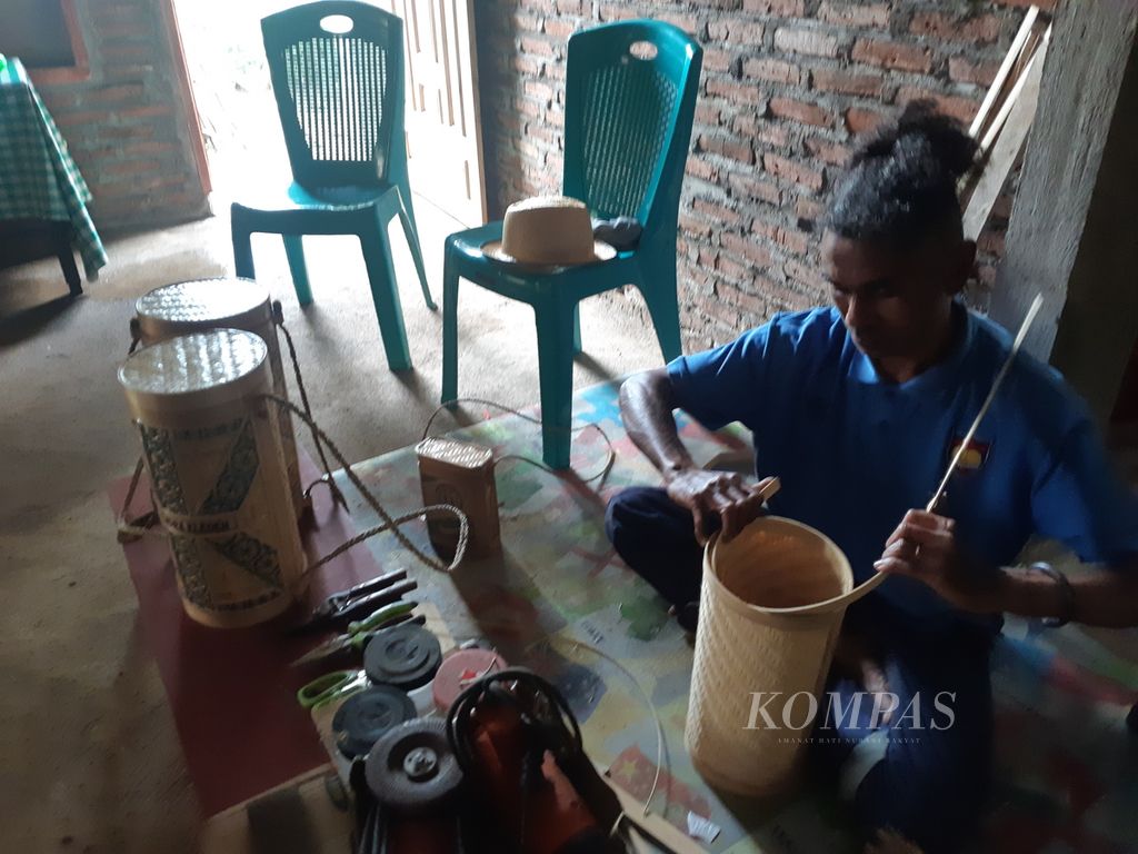 Philipus Dadu Tukan tengah menyelesaikan pembuatan tas tabung di rumahnya di Desa Blepanawa, Kecamatan Demon Pagong, Kabupaten Flores Timur, Nusa Tenggara Timur, Kamis (6/4/2023) petang.