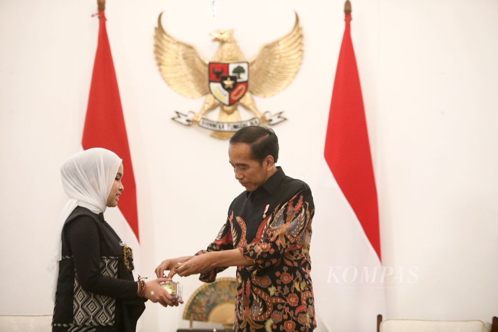 Putri Ariani menujukkan potongan kertas emas setelah mendapatkan <i>golden buzzer</i> dalam ajang Americas Got Talent kepada Presiden Joko Wododo di Istana Merdeka, Jakarta, Rabu (14/6/2023).