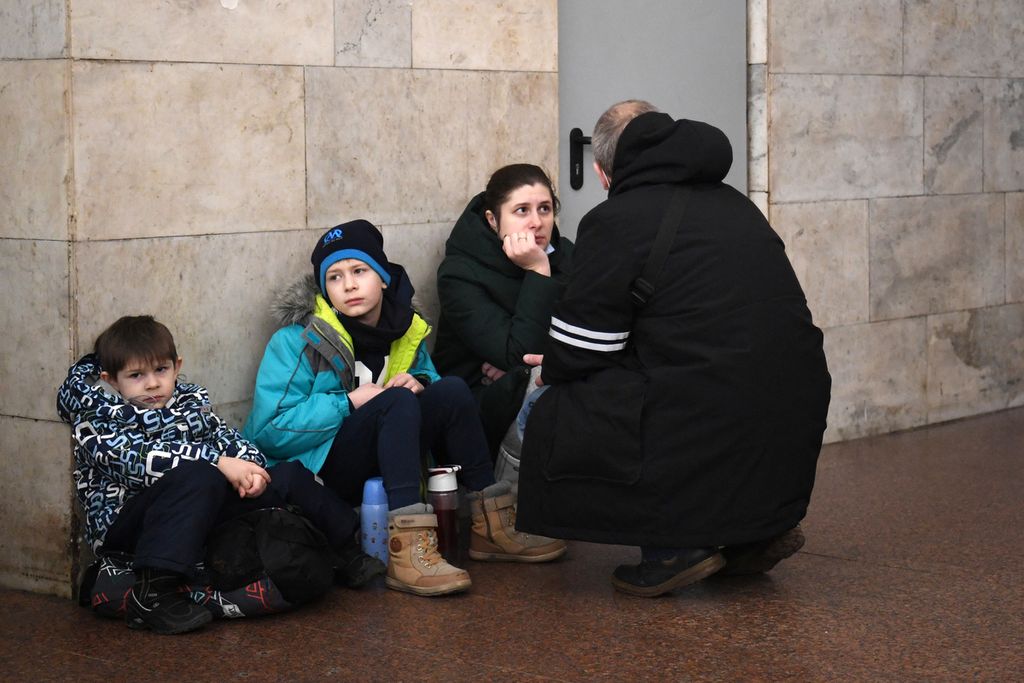 Sebuah keluarga berlindung di stasiun metro di Kiev pada pagi hari 24 Februari 2022. Sirene serangan udara terdengar di pusat kota Kiev hari ini ketika sejumlah wilayah di Ukraina terkena serangan rudal dan artileri Rusia.