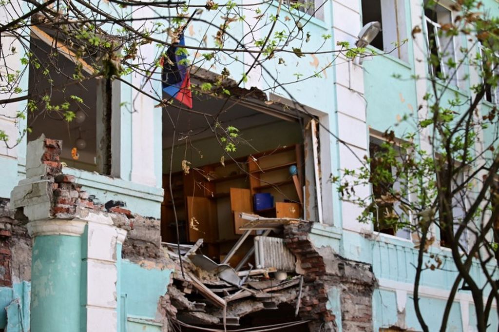 Foto yang diambil pada 13 Juni 2022 menunjukkan pintu masuk sekolah nomor 22 yang hancur, yang ditembaki pada 30 April di Donetsk, Ukraina timur, di tengah aksi militer Rusia yang sedang berlangsung di Ukraina. 