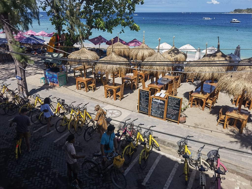 Wisatawan memarkir sepeda mereka sebelum bersantai di Carpe Diem Cafe and Restaurant di kawasan Gili Trawangan, Lombok Utara, Nusa Tenggara Barat, Selasa (10/1/2023). Saat ini, pariwisata di kawasan gili kembali menggeliat setelah sempat lesu akibat pandemi Covid-19.