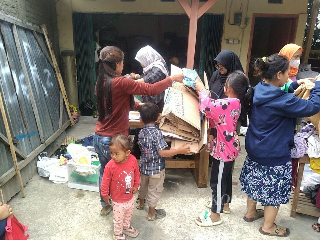 Warga Kampung Cilalareun, Desa Cipanjalu, Kecamatan Cilengkrang, Kabupaten Bandung, Jawa Barat, menyerahkan kardus dan sampah terpilah lainnya untuk nanti ditukarkan dengan sejumlah barang di pasar barter, Minggu (26/11/2023).