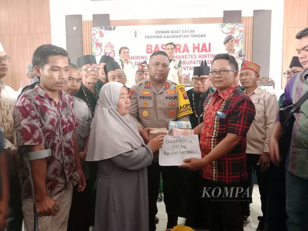Perwakilan PT HMBP dan Polda Kalteng memberikan denda adat di sela-sela sidang adat Dayak di Kota Palangka Raya, Kalimantan Tengah, Jumat (19/4/2024). Taufik merupakan salah satu korban yang terkena tembakan peluru tajam.