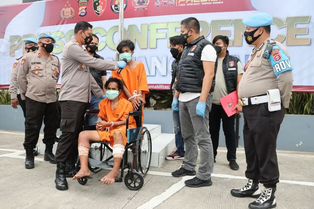 IS (berdiri) dan GG (di kursi roda) adalah tersangka penganiayaan, pemerkosaan, pencurian, dan percobaan pembunuhan terhadap SP, karyawati dari Tigaraksa, Banten, ketika dihadirkan dalam rilis di Polresta Tangerang, Selasa (25/1/2022).