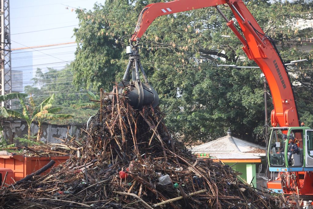  Alat berat Unit Pelaksana Kebersihan Badan Air DKI Jakarta mengeruk tumpukan berbagai sampah, seperti batang pohon, bambu, styrofoam, dan plastik, serta berbagai sampah rumah tangga di Pintu Air Manggarai, Jakarta Selatan, Rabu (9/10/2019). Hujan yang turun di awal musim hujan telah menambah debit air Kali Ciliwung. Aliran air sungai membawa serta sampah beserta dahan-dahan pohon di bantaran kali yang terbawa arus dan menumpuk di Pintu Air Manggarai, Jakarta.