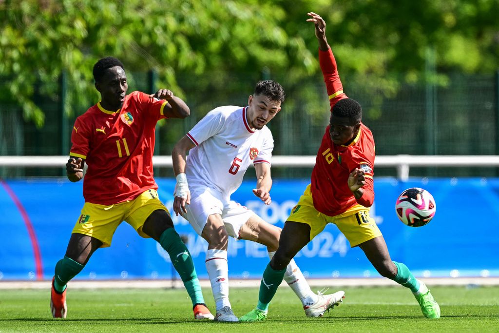Indonesian midfielder, Ivar Jenner (center), fights for the ball with Guinean striker, Ousmane Camara (left), and Guinean midfielder, Aguibou Camara, during the 2024 Olympics playoff match in Clairefontaine-en-Yvelines, Thursday (9 /5/2024).