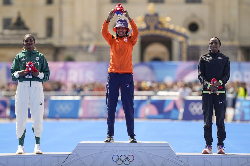 Dari kiri ke kanan: Peraih medali perak maraton putri pelari Etiopia, Tigst Assefa, peraih medali emas pelari Belanda, Sifan Hassan, dan peraih perunggu pelari Kenya, Hellen Obiri, memamerkan medali Olimpiade Paris 2024 yang mereka rebut di Paris, Perancis, Minggu (11/8/2024).