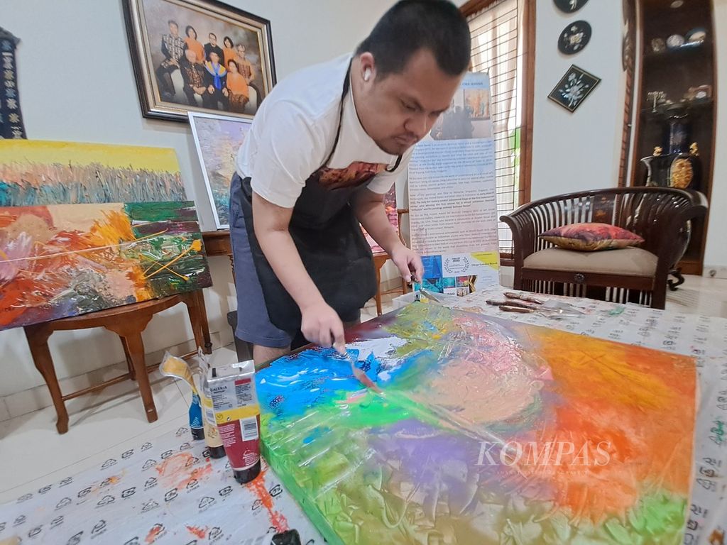 Diego Luister Berel, pelukis dengan <i>down syndrome</i>, tengah berkreasi di rumahnya di Jakarta, Kamis (25/5/2023). 