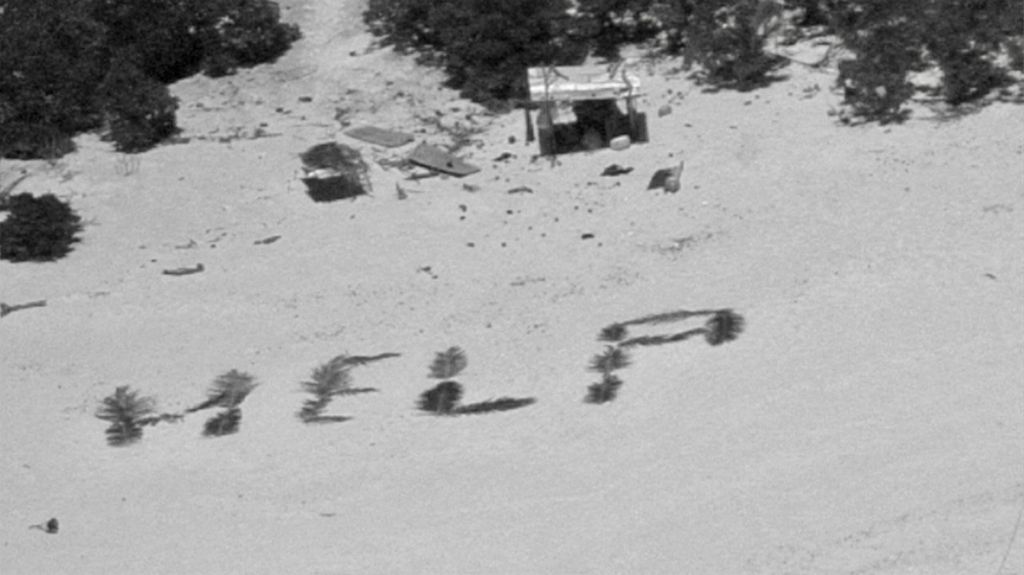 Foto yang diperoleh dari Penjaga Pantai AS pada 11 April 2024 menunjukkan tulisan &quot;TOLONG&quot; di pantai yang dibuat dengan daun kelapa oleh tiga marinir yang terdampar di Atol Pikelot, Federasi Negara-negara Mikronesia. 