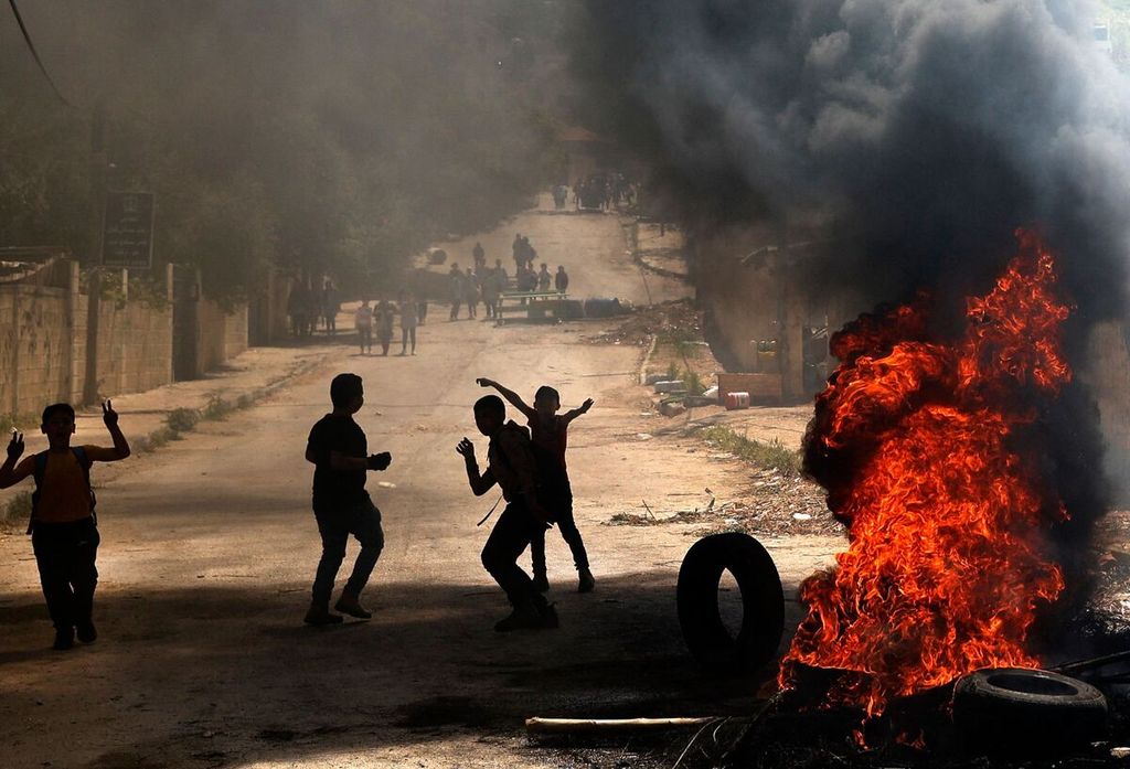 Anak-anak Palestina membakar ban-ban menyusul penggerebekan oleh militer Israel di Jenin, wilayah pendudukan Tepi Barat, Selasa (12/4/2022).