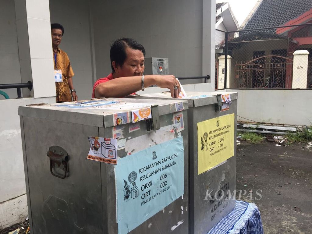 Seorang warga Kelurahan Buakana, Kecamatan Rappocini, Makassar, Sulawesi Selatan, memasukkan surat suara ke dalam kotak suara dalam pemilihan Ketua RT/RW serentak se-Kota Makassar yang digelar, Minggu (26/2). ()