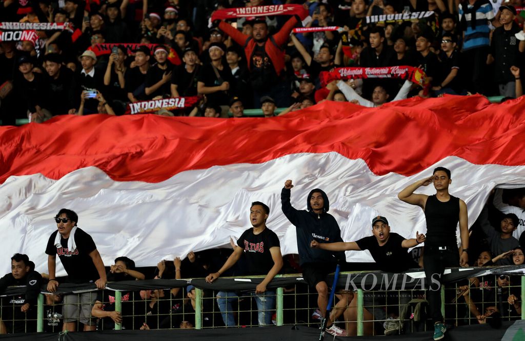 Suporter membentangkan M"erah-Putih" saat mendukung tim nasional sepak bola U-19 Indonesia dalam laga penyisihan Grup A Piala AFF U-19 2022 di Stadion Patriot Candrabhaga, Bekasi, Jawa Barat, Sabtu (2/7/2022). Laga itu berakhir, 0-0. 