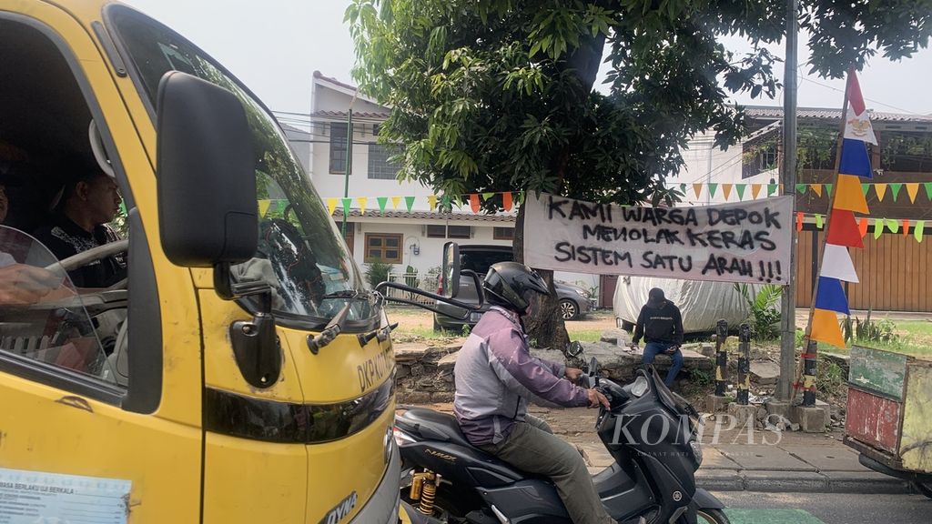 Spanduk penolakan warga terkait pemberlakuan rekayasa lalu lintas sistem satu arah (SSA) di Jalan Nusantara Raya, Depok, Jawa Barat, Senin (7/8/2023).