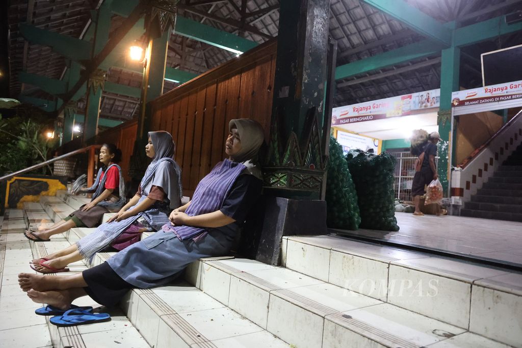 Buruh gendong menunggu pedagang yang akan menggunakan jasa mereka di Pasar Beringharjo, Yogyakarta, Selasa (7/3/2023) dini hari.