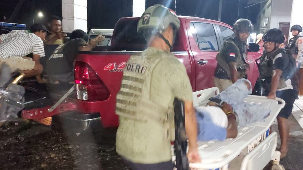 Aparat kepolisian mengevakuasi salah satu dari dua warga yang tewas akibat ditembak orang tak dikenal di Distrik Deikai, ibu kota Kabupaten Yahukimo, Papua Pegunungan, Rabu (8/3/2023). Kelompok kriminal bersenjata diduga berada di balik peristiwa ini.