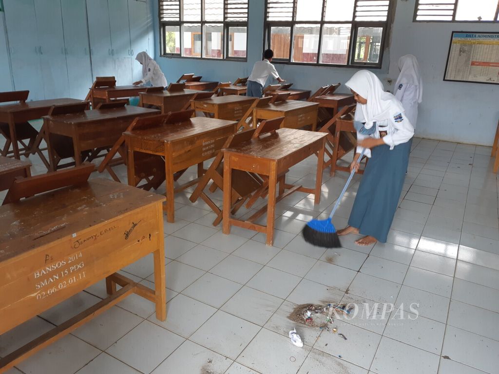 Pelajar membersihkan ruangan kelas pada hari pertama sekolah usai masa libur semester di SMAN 15 Pandeglang, Kecamatan Carita, Kabupaten Pandeglang, Banten, Senin (7/1/2019)