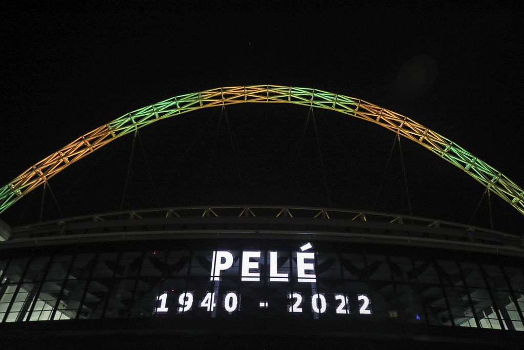 Busur penopang Stadion Wembley bersinarkan cahaya hijau dan kuning, warna nasional Brasil, saat mengumumkan wafatnya bintang sepak bola Brasil, Pele, di London, Inggris, Kamis (29/12/2022). Edson Arantes do Nascimento alias Pele meninggal di Sao Paulo, Brasil, dalam usia 82 tahun. 