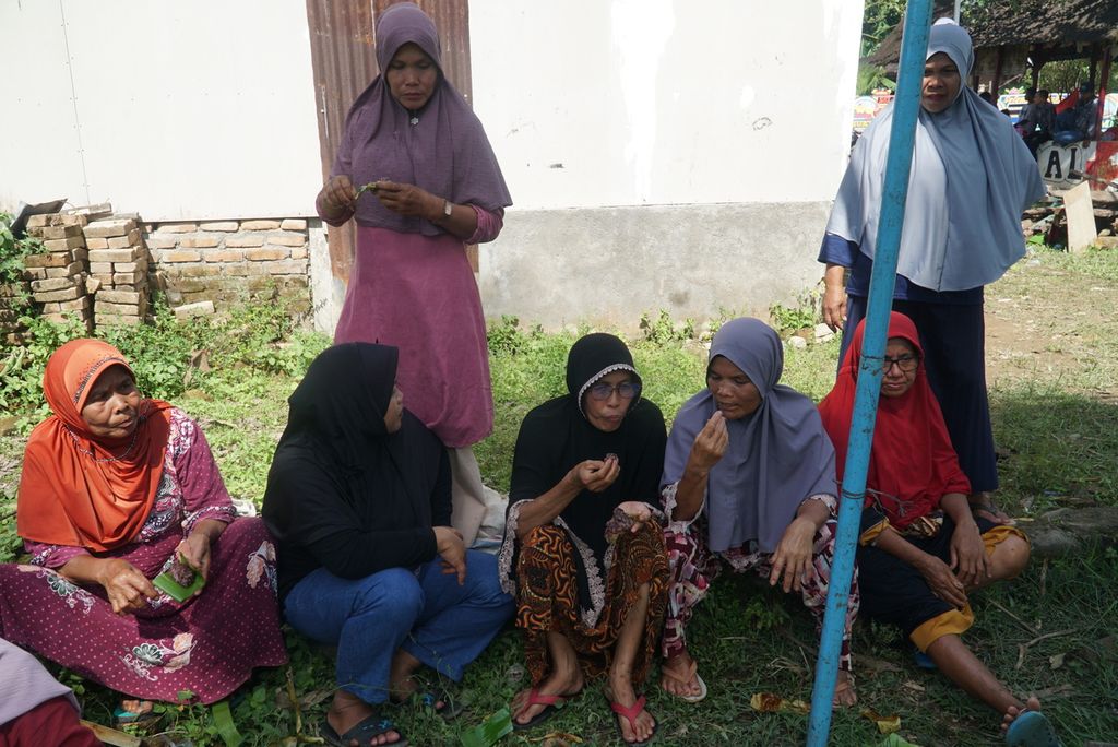 Warga menikmati lamang (lemang) yang mereka masak dalam acara "Malamang Sakampuang" di Kelurahan Aie Pacah, Kecamatan Koto Tangah, Kota Padang, Sumatera Barat, Sabtu (31/12/2022). 